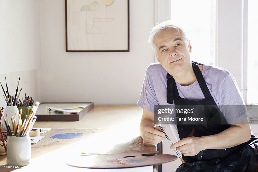 Mature man painting in studio