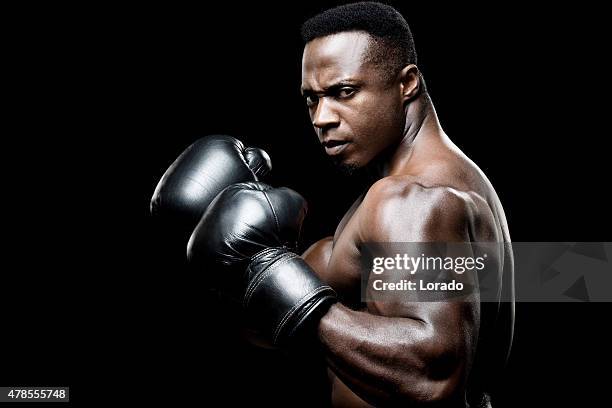 black male boxer posing with raised fists - boxing heavyweight stock pictures, royalty-free photos & images