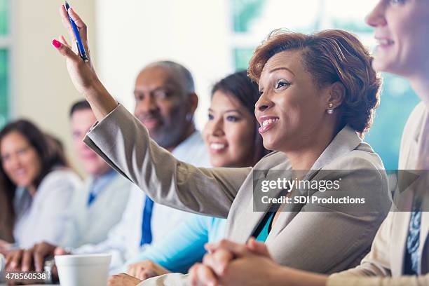 african american businesswoman raising hand, asking question in business conference - manquestionmark stock pictures, royalty-free photos & images