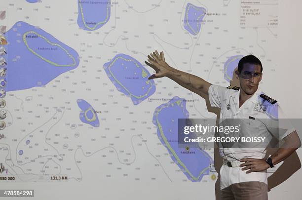 Member of the French Navy shows a map displaying the atoll of Toau on June 25, 2015 two days after Swiss yachtsman Laurent Bourgnon was reported...