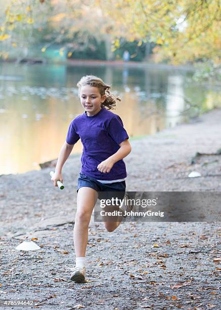 young girl running cross country relay race - track and field baton stock pictures, royalty-free photos & images