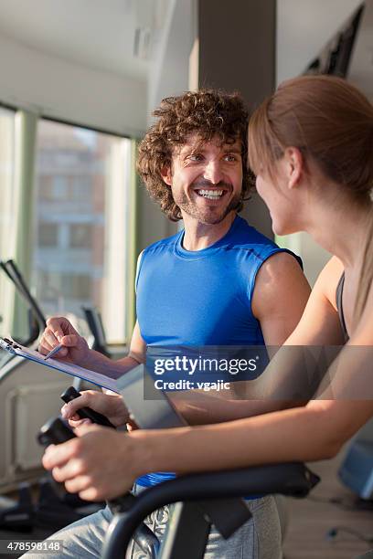 young woman with personal trainer in the gym - non moving activity stock pictures, royalty-free photos & images