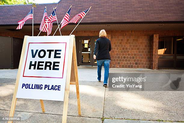 woman voter entering voting polling place for usa government election - röstregistrering bildbanksfoton och bilder