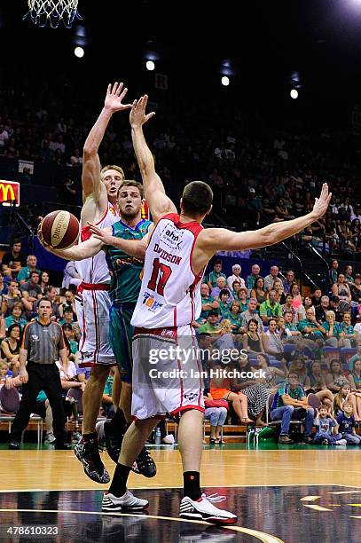 Mitch Norton of the Crocodiles gets a pass away in-between two hawks defenders during the round 22 NBL match between the Townsville Crocodiles and...