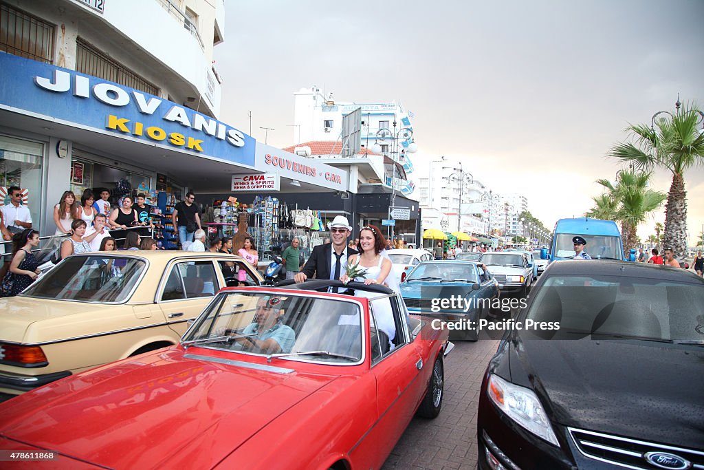 The couple ride on a vintage car in their way to the...