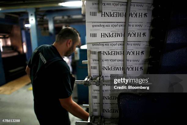Print worker checks as newly printed editions of the Kathimerini daily newspaper roll through the automated production line at the Kathimerini...