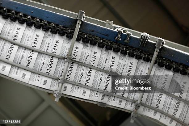 Newly printed editions of the daily newspaper Kathimerini roll through the automated production line at the Kathimerini Publishing SA printing plant...