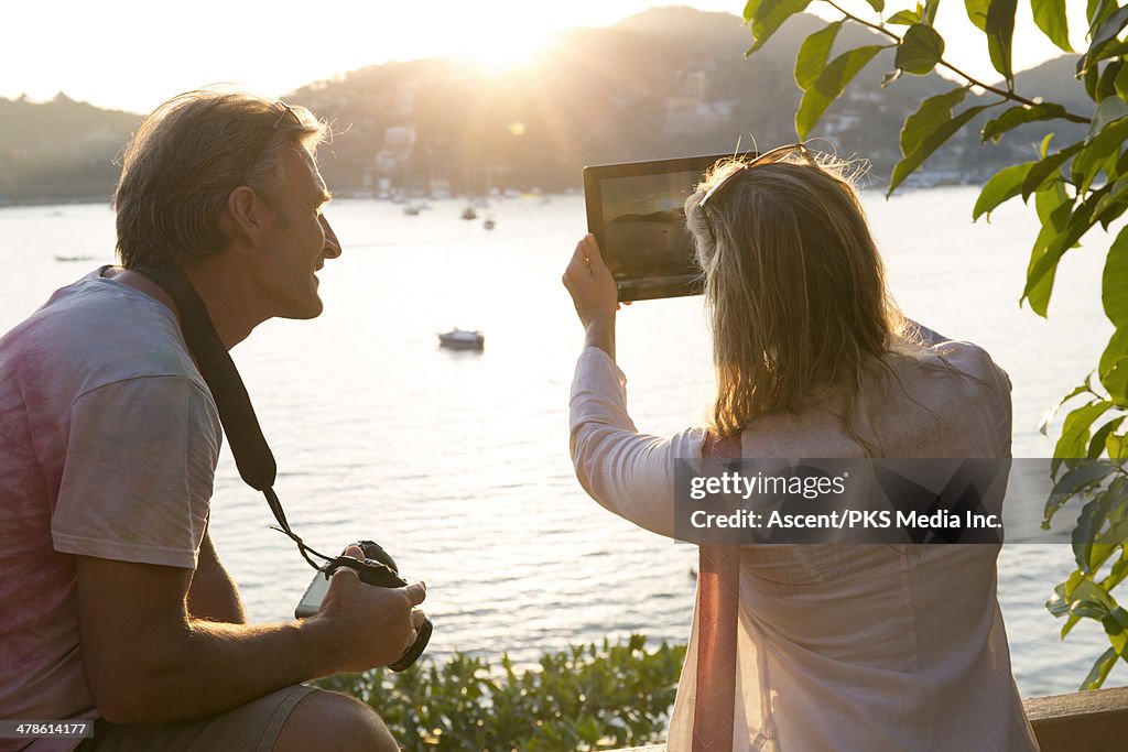 Couple taking pictures over ocean bay