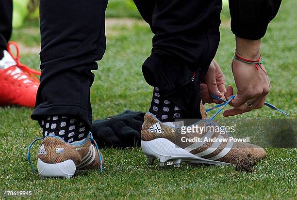 Luis Suarez of Liverpool puts his new knitted boots on before a training session at Melwood Training Ground on March 14, 2014 in Liverpool, England.