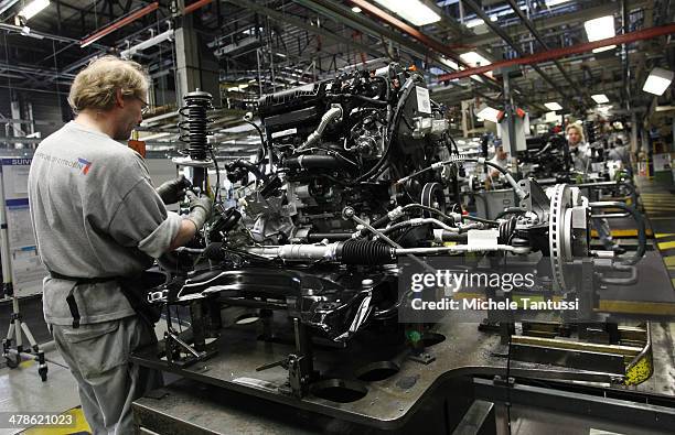 Workers works on the Engine of a Peugeot 2008 SUVs at the PSA Peugeot Citroen assembly plant on March 14, 2014 in Mulhouse, France. Chinese automaker...