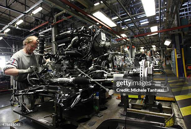 Workers works on the Engine of a Peugeot 2008 SUVs at the PSA Peugeot Citroen assembly plant on March 14, 2014 in Mulhouse, France. Chinese automaker...