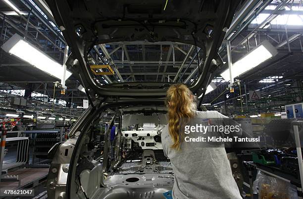 Workers assemble Peugeot 2008 SUVs at the PSA Peugeot Citroen assembly plant on March 14, 2014 in Mulhouse, France. Chinese automaker Dongfeng is...
