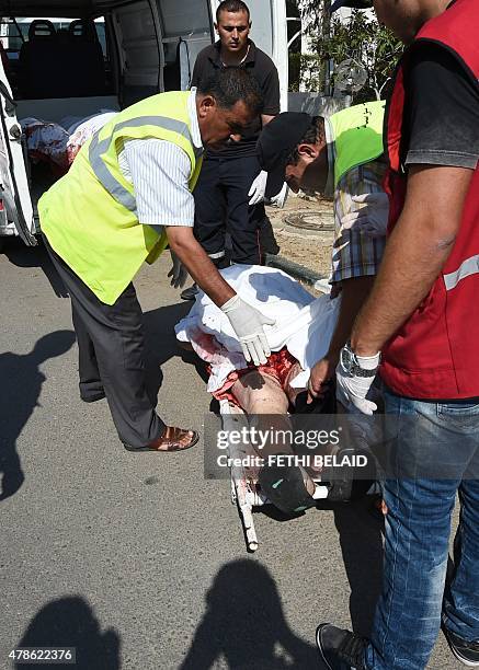 Tunisian medics stand next to the bodies of tourists in the resort town of Sousse, a popular tourist destination 140 kilometres south of the Tunisian...