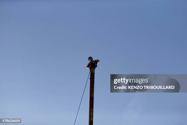 French gendarme trying out for the National Gendarmerie Intervention Group stands on a beam situated atop a tower on the fifth day of recruitment...