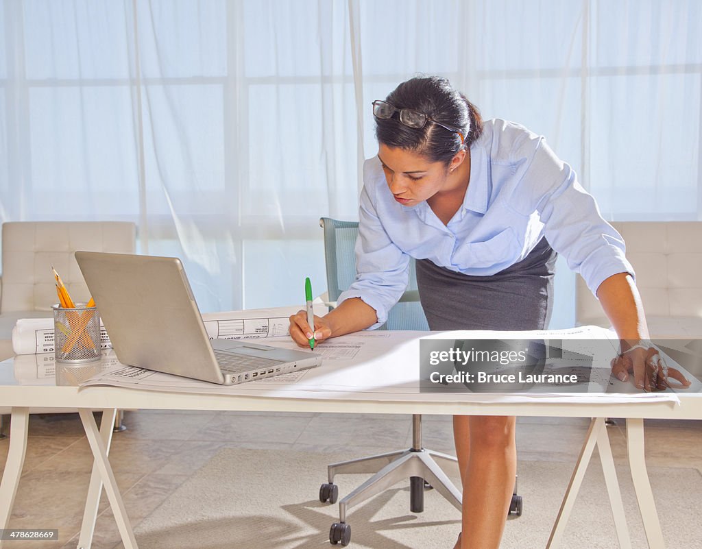 Woman working on blueprints