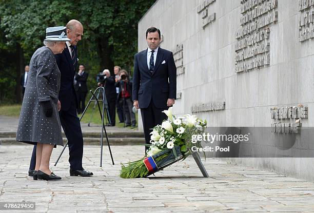 Queen Elizabeth II and Prince Philip, Duke of Edinburgh lay a wreath at the inscription wall during their visit of the concentration camp memorial at...