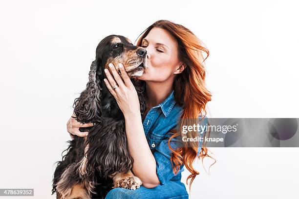 beautiful redhead woman on her 40s with her dog - kissing photos stockfoto's en -beelden