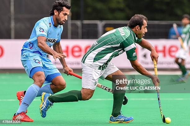 India's Dharamvir Singh vies with Pakistan's Mahmood Rashid during the field hockey match between Pakistan and India in the men's Group A of the...