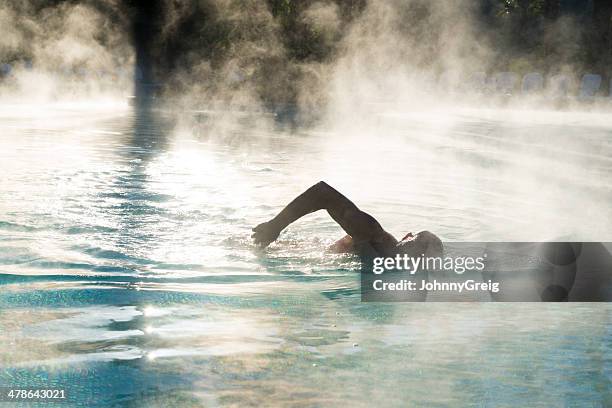 silhouette eines mannes schwimmen wie dampf fahrten vom pool - dampf stock-fotos und bilder
