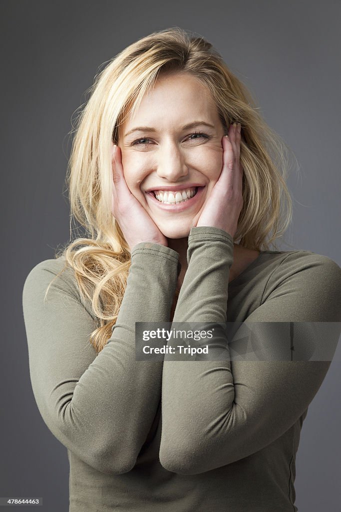 Woman smiling with hands on face