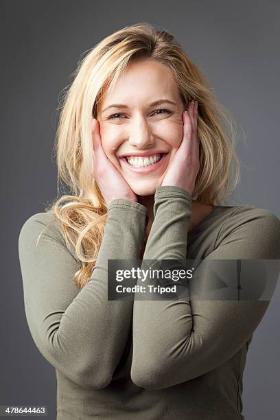 woman smiling with hands on face - blonde hair brown eyes stock pictures, royalty-free photos & images