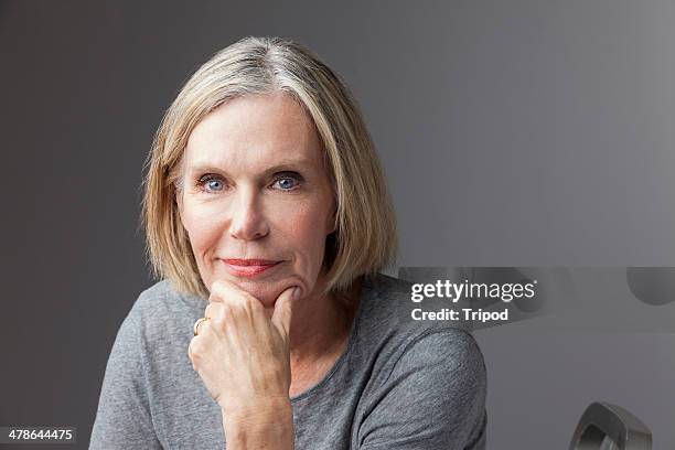 mature woman with hand on chin, portrait - 60 woman stockfoto's en -beelden