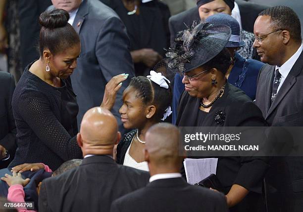 First Lady Michelle Obama greets Eliana Pinckney , the daughter of the slain Reverend and South Carolina State Sen. Clementa Pinckney, as Pinkney's...