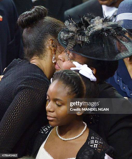 First Lady Michelle Obama hugs Jennifer Pinckney , the wife of the slain Rev. And South Carolina State Sen. Clementa Pinckney, as Pinckney's daugher...