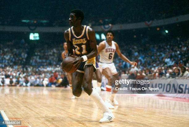 Michael Cooper of the Los Angeles Lakers drives towards the basket against the Philadelphia 76ers during an NBA basketball game circa 1980 at The...