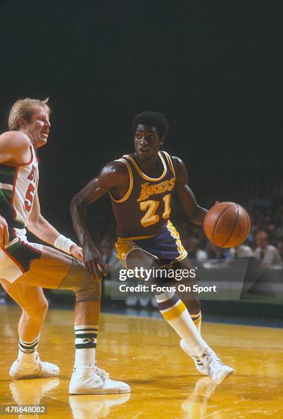 Michael Cooper of the Los Angeles Lakers drives past Kent Benson of the Milwaukee Bucks during an NBA basketball game circa 1980 at the MECCA Arena...