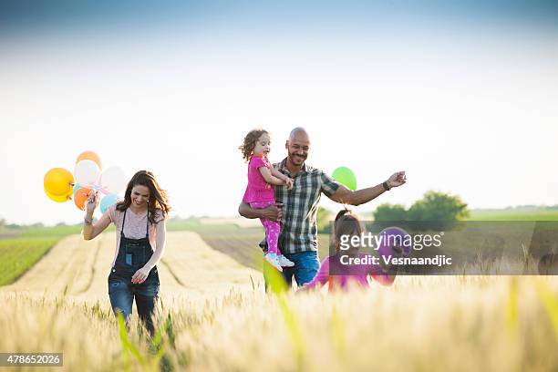 magnifique multi ethnique famille courir à travers champ de blé - father son outdoor celebration photos et images de collection