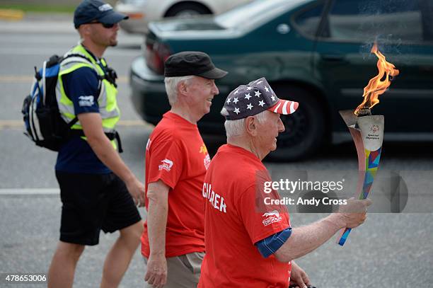 Sam Perry, right, walks with the Special Olympics Unified Relay Across America Flame of Hope along Parker Ave. Near Dartmouth St. With Don Roth,...