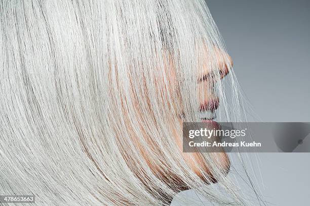 grey haired woman profile with hair covering face. - pretty older women stockfoto's en -beelden