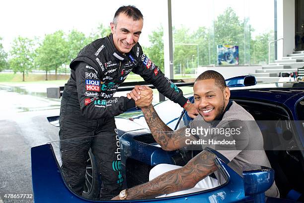 In this handout photo provided by Maserati, Pro racecar driver Andrea Bertolini visits with New York Knicks basketball player and NBA All-Star,...