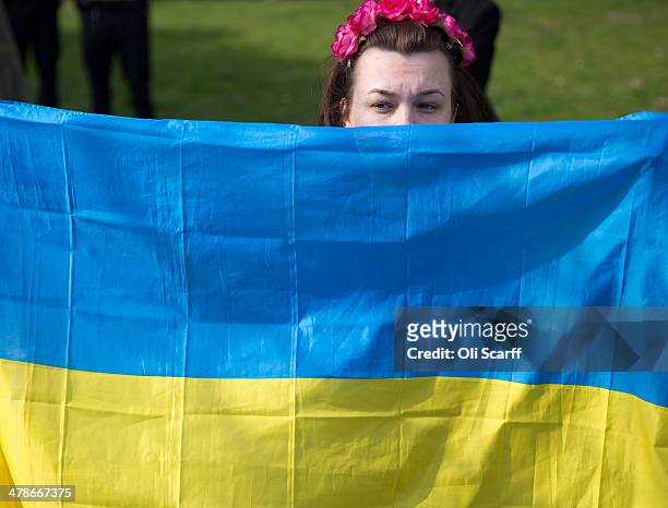 Protester holds a Ukrainian flag outside Winfield House, the residence of the US Ambassador to the UK, where talks are taking place between US...