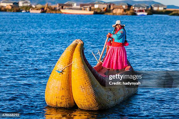 peruano mujer navegación entre islas flotantes de uros, el lago tititcaca - departamento de puno fotografías e imágenes de stock