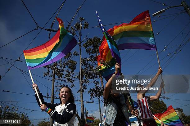 Same-sex marriage supporters wave pride flags while celebrating the U.S Supreme Court ruling regarding same-sex marriage on June 26, 2015 in San...
