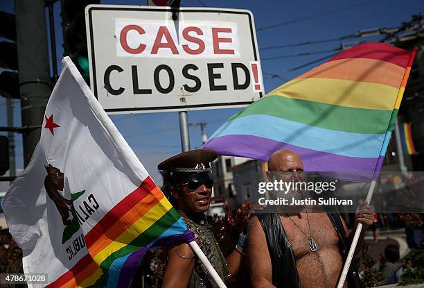 Same-sex marriage supporters hold pride flags next to an altered street sign that reads "case closed!' while celebrating the U.S Supreme Court ruling...