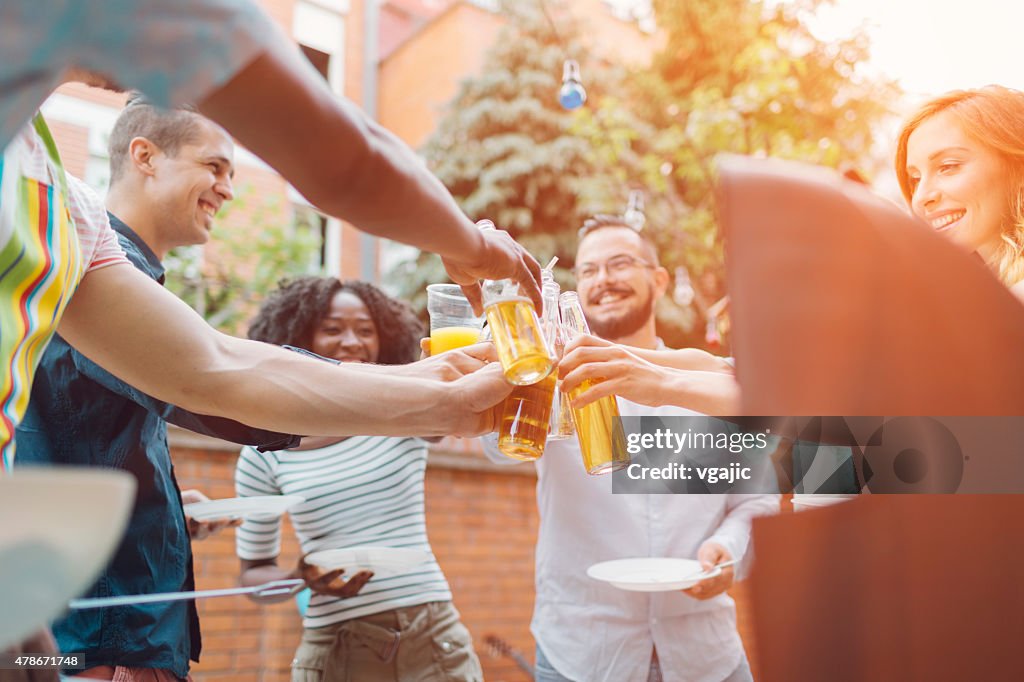 Happy Young People Toasting At Barbecue Party.