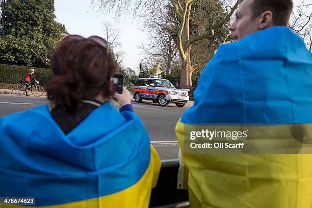 Protesters chant and wave Ukrainian flags as US Secretary of State, John Kerry's motorcade leaves Winfield House, the residence of the US Ambassador...