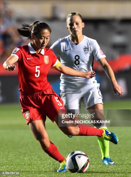 Player Amy Rodriguez looks on as China's Wu Haiyan kicks the ball during a 2015 FIFA Women's World Cup quarterfinal match between the US and China at...