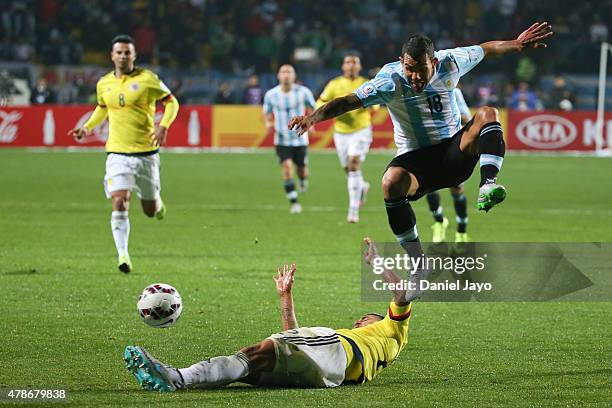 Carlos Tevez of Argentina jumps over Jeison Murillo of Colombia during the 2015 Copa America Chile quarter final match between Argentina and Colombia...