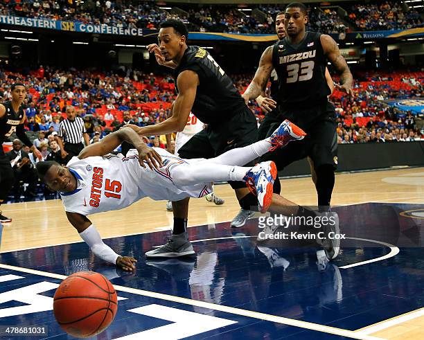 Will Yeguete of the Florida Gators looses the ball out of bounds against Johnathan Williams, III and Earnest Ross of the Missouri Tigers during the...