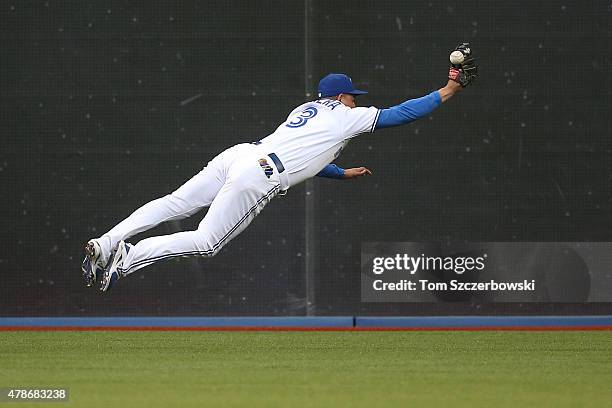 Ezequiel Carrera of the Toronto Blue Jays dives but cannot grab a single in the fourth inning during MLB game action hit by Mitch Moreland of the...