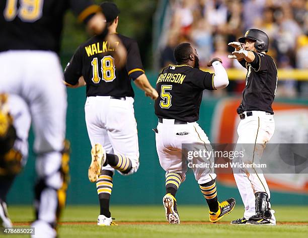 Jordy Mercer of the Pittsburgh Pirates is congratulated by teammates Josh Harrison and Neil Walker after hitting the game winning walk off RBI single...