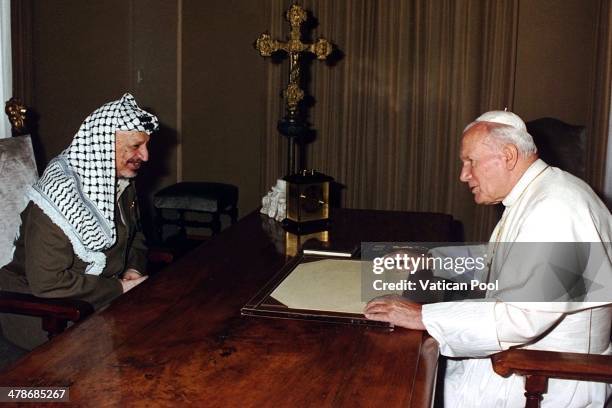 Pope John Paul II exchanges gifts with Palestinian leader Yasser Arafat at his summer residence on September 2, 1995 in Castel Gandolfo, Italy.