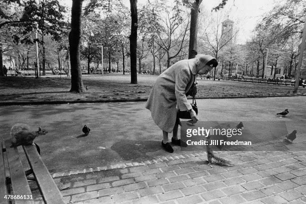 An elderly lady feeding a squirrel in Washington Square Park, Greenwich Village, New York City, 1972.