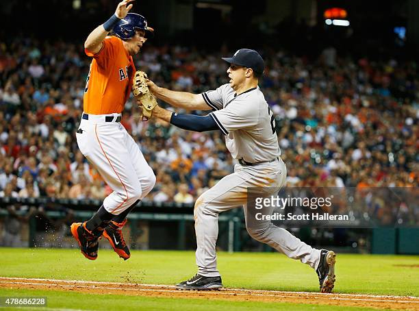 Colby Rasmus of the Houston Astros is tagged out at first base by Mark Teixeira of the New York Yankees in the ninth inning of their game at Minute...