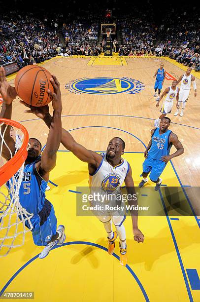 Bernard James of the Dallas Mavericks rebounds against Draymond Green of the Golden State Warriors on March 11, 2014 at Oracle Arena in Oakland,...