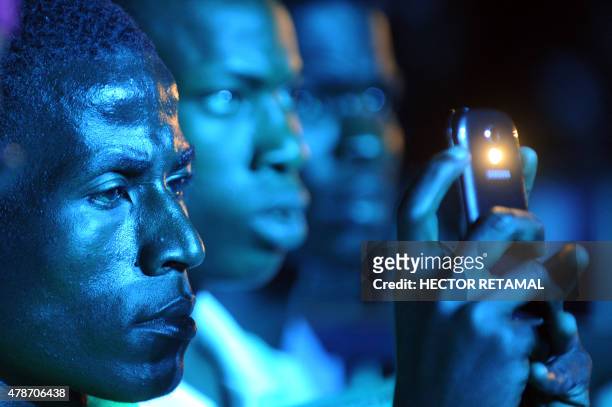 Fans wait for a free concert by singers Chris Brown and Lil Wayne in Champ de Mars, downtown Port-au-Prince on June 26, 2015. AFP PHOTO/HECTOR RETAMAL